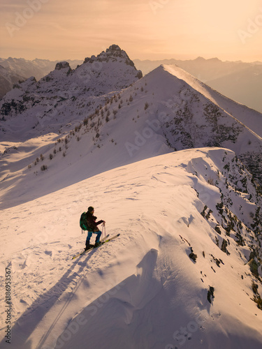 Canvas Print Lone Hiker on Snowy Mountain Ridge at Golden Hour