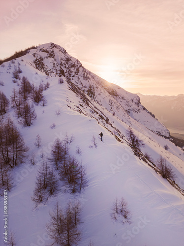 Fotografija Lone Hiker on Snowy Mountain at Golden Hour