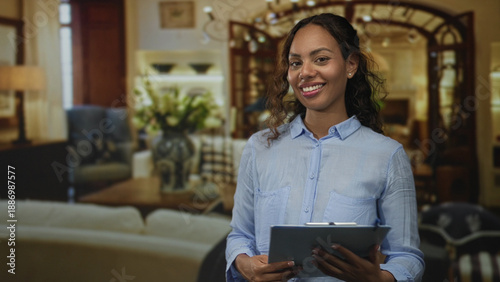 Fotografie Woman holding clipboard and smiling while reading notes in a living room set inside a building; confidence helpful guidance