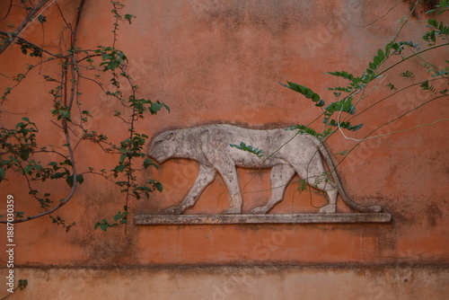 Принти на полотні A stone bas-relief of a walking panther or lion on an ancient terracotta-colored