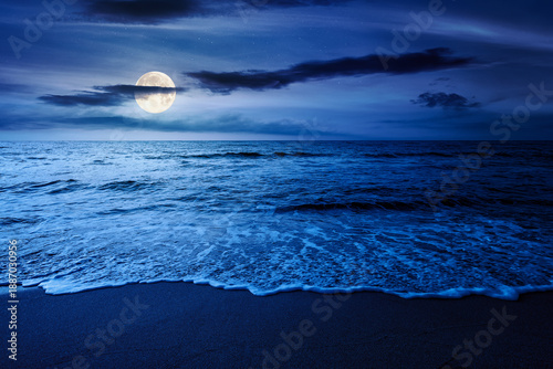 sand beach at the sea for summer vacation concept. beautiful night at perfect coast with calm waves and clouds on sky in full moon light. landscape for finance investment or abstract concepts