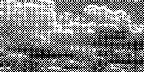 A grainy monochrome image depicting a cloudy sky and distant landscape