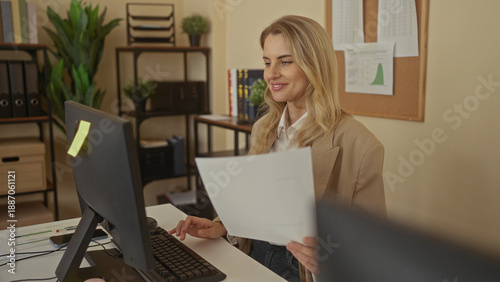 Foto Woman working in modern office environment with computer blonde hair wearing bei