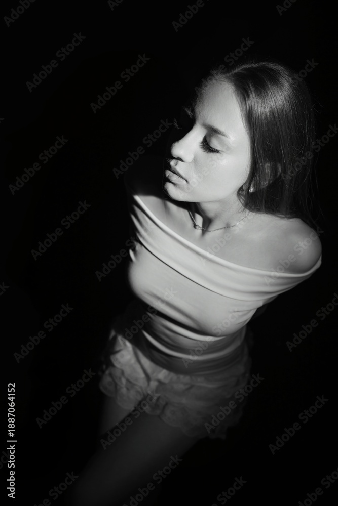 Naklejka premium Black and white photos of a girl on a black background. Beautiful young model