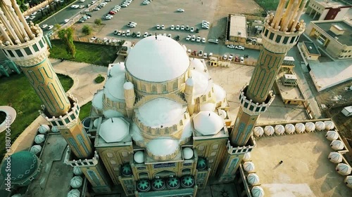 Aerial fly-cam view over the grand central dome of Jalil Al-Khayyat Mosque in Erbil, featuring intricate Ottoman architecture and minarets under a clear sky in Iraqi Kurdistan.