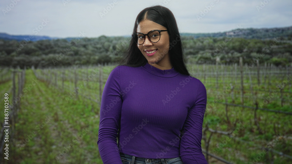 Fototapeta premium Young latin woman removes black frame glasses with both hands in forest clearing under overcast sky; calm reflection.