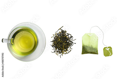 Fresh green tea leaves brewing in glass cup with loose leaves and tea bag on white background