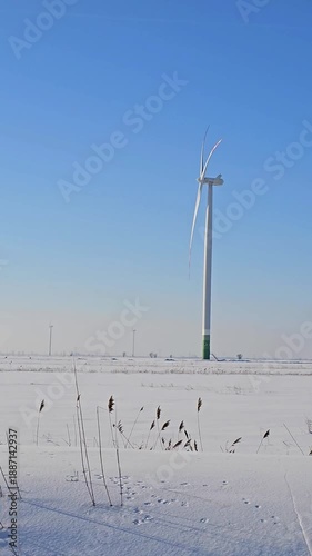 Wind turbines operating in a snowy winter landscape, symbolizing clean energy in cold weather conditions.