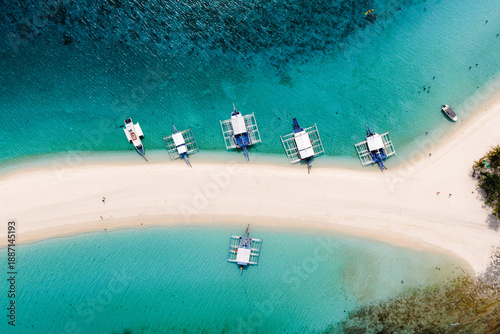 Stunning White Sandbar of Kalanggaman Island with Traditional Bangka Boats Docked in the Philippines.