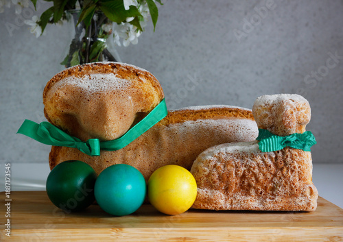 Easter still life with traditional lamb cakes, painted eggs and blooming cherry branches in vase, spring holiday baking concept, rustic home decoration and festive atmosphere