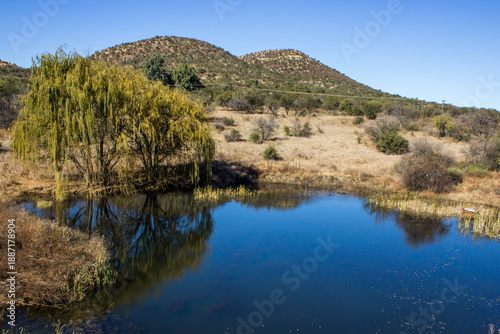 A small farm dam, on a sunny day, between the high ridges of the Vredefort Dome, rural South Africa.