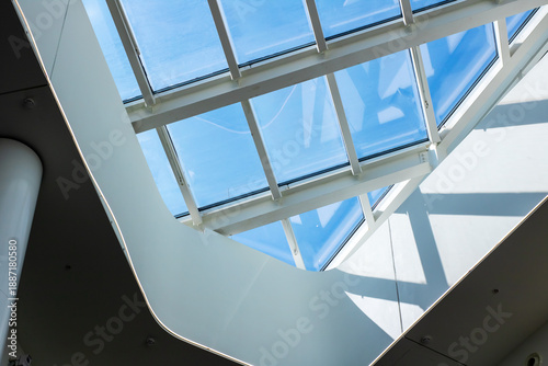 Elegant white ceiling with triangular skylights casting highcontrast shadows and slim metal framing