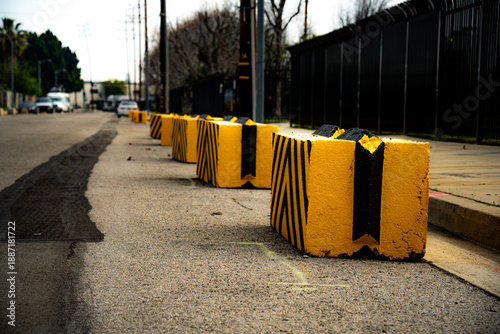 Photography Yellow and black concrete barriers line a street, indicating a restricted area o