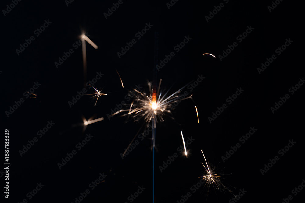 Obraz premium a match ignites a sparkler, fireworks on a black background