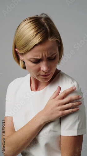 Young Woman Holding Shoulder With Pain Expression