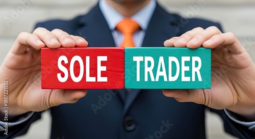 Man holding two wooden blocks, one red with 'SOLE' and one green with 'TRADER', symbolizing entrepreneurship, independent business ownership, and small business concepts.