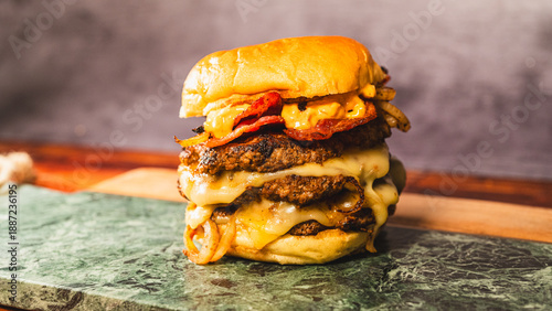 Obraz na plátne Massive triple patty smash burger with crispy bacon, homemade sauce, and onions