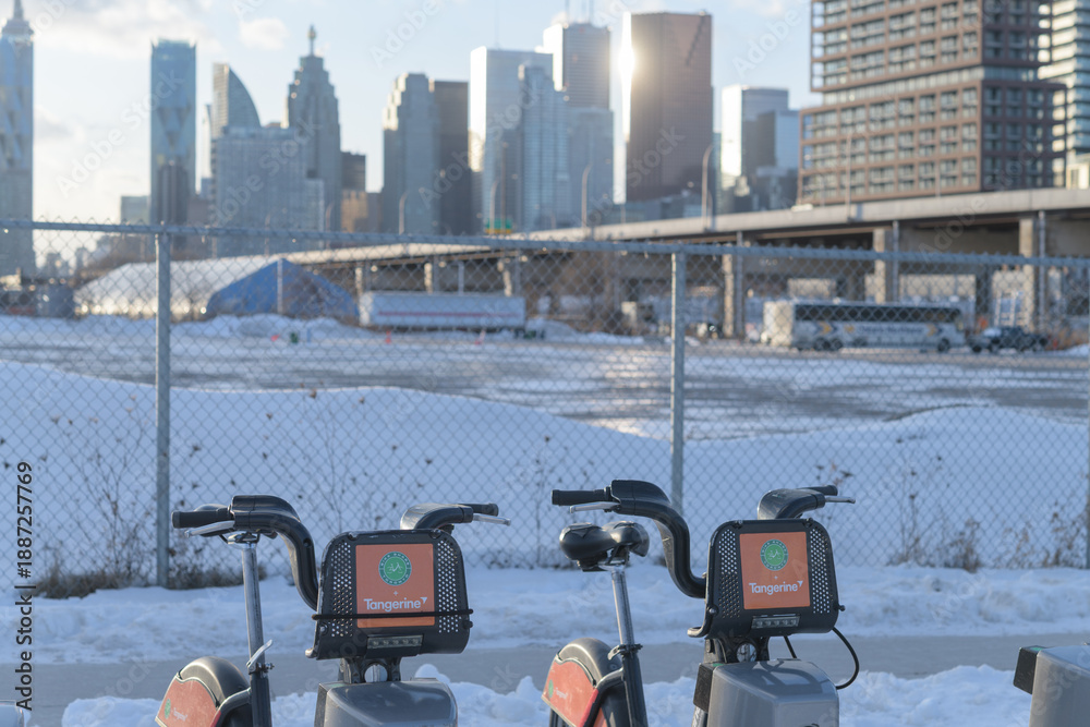 Obraz premium rental bikes with defocused view of downtown Toronto in winter