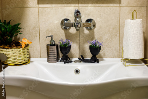 Fotografía Modern bathroom sink with chrome wall-mounted faucet, soap dispenser, paper towe