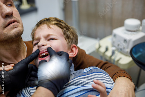 фотографія Pediatric dentist examining child teeth in clinic with parent support, close-up