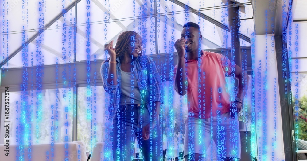 Naklejka premium Smiling couple standing chatting in bright atrium, in denim and coral polo with blue code overlay