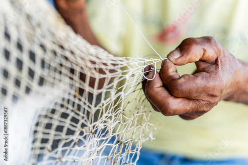 Cuadro en lienzo Artisanal fisherman hands repairing fishing net Caribbean Coast Colombia close-u