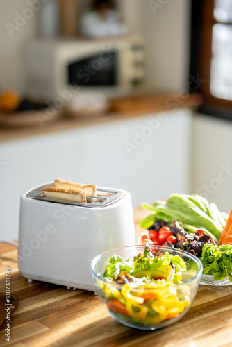 The kitchen has toast and salad laid out on the table, ready for breakfast.