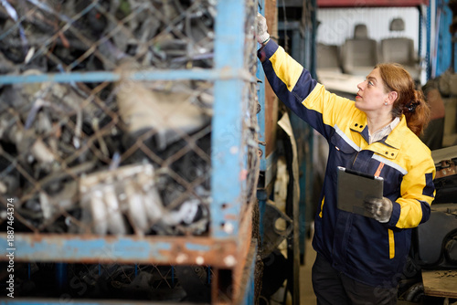 Foto Worker examines metallic scrap inside a factory