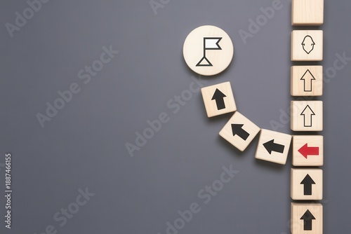 Business strategy concept with wooden blocks showing path deviation towards a goal flag on dark background