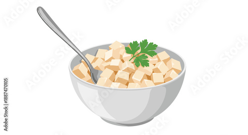 Simple white bowl filled with diced tofu cubes is garnished with a fresh green parsley leaf and includes a silver spoon.