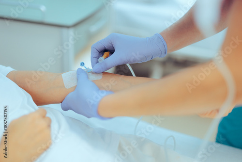 Photos Medical Assistant inserting IV Cannula to a Patient for Treatment