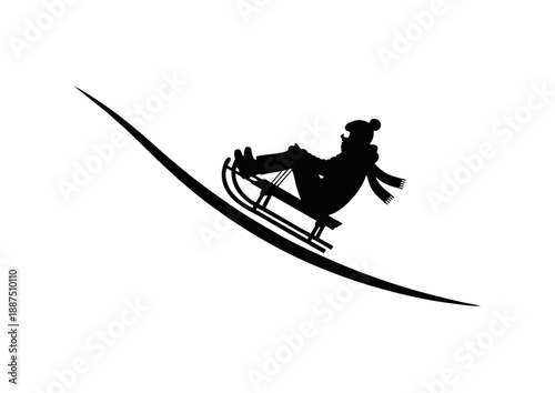 Silhouette of a person in winter clothing joyfully sledding down a snowy slope during wintertime