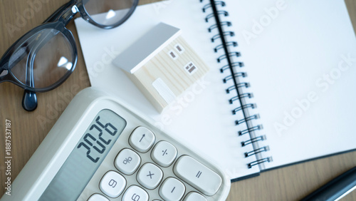 Foto Calculator, notebook and small house model on wooden desk, concept of home insurance planning, mortgage calculation and personal financial protection