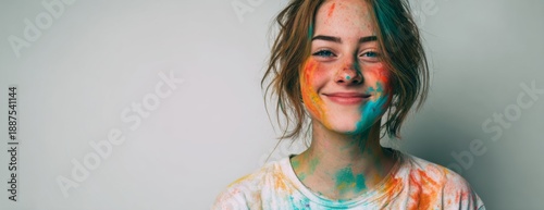 Young woman smiling with colorful powder on her face after Holi festival  