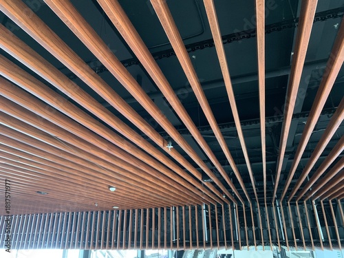 Photos Modern architectural ceiling design featuring parallel metal slats with visible fixtures such as lights and sprinklers