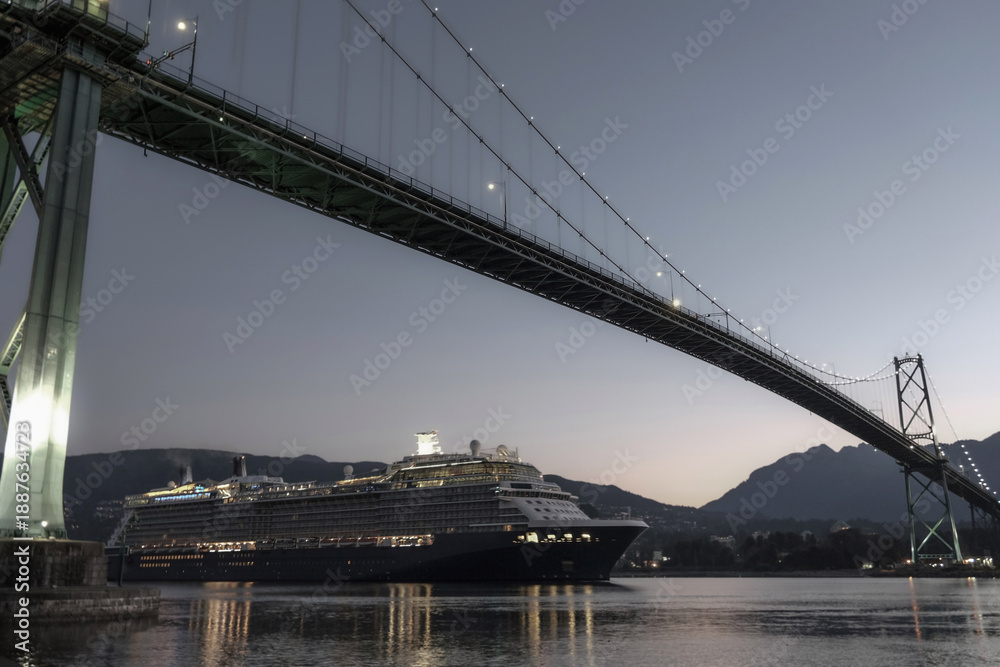 Obraz premium Modern luxury cruiseship cruise ship liner Solstice returning to Vancouver, BC Canada from Alaska cruise during sunrise early morning blue hour harbor landscape marine traffic city skyline silhouette