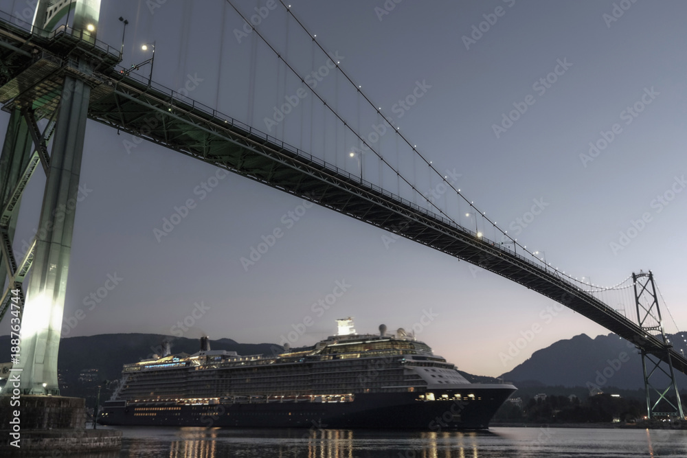 Fototapeta premium Modern luxury cruiseship cruise ship liner Solstice returning to Vancouver, BC Canada from Alaska cruise during sunrise early morning blue hour harbor landscape marine traffic city skyline silhouette