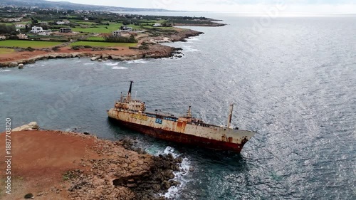 High-angle drone view of the EDRO III shipwreck near the Cyprus shoreline. Isolated cargo vessel trapped on rocks by the Mediterranean Sea.
