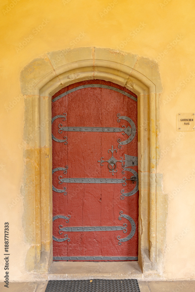 Fototapeta premium Old red door in Treves, Germany, with ornate ironwork