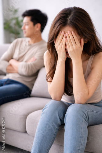 Family problems, Asian women cover her face and sit separately from husband feel disappointed after quarrels at home.