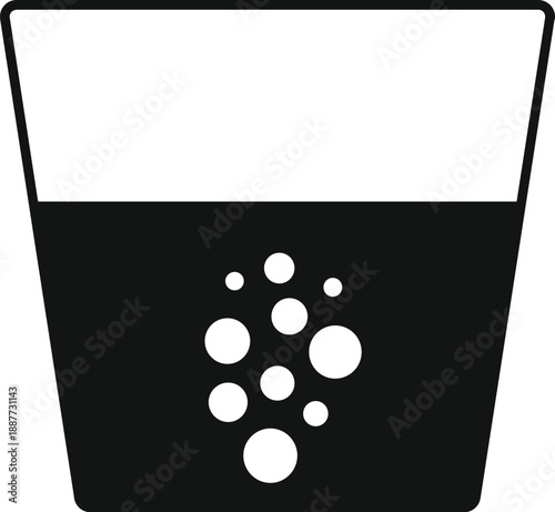 Drinking glass filled with carbonated beverage and rising air bubbles