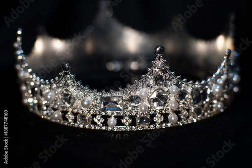 White golden crown with crystals, diamonds on black background.