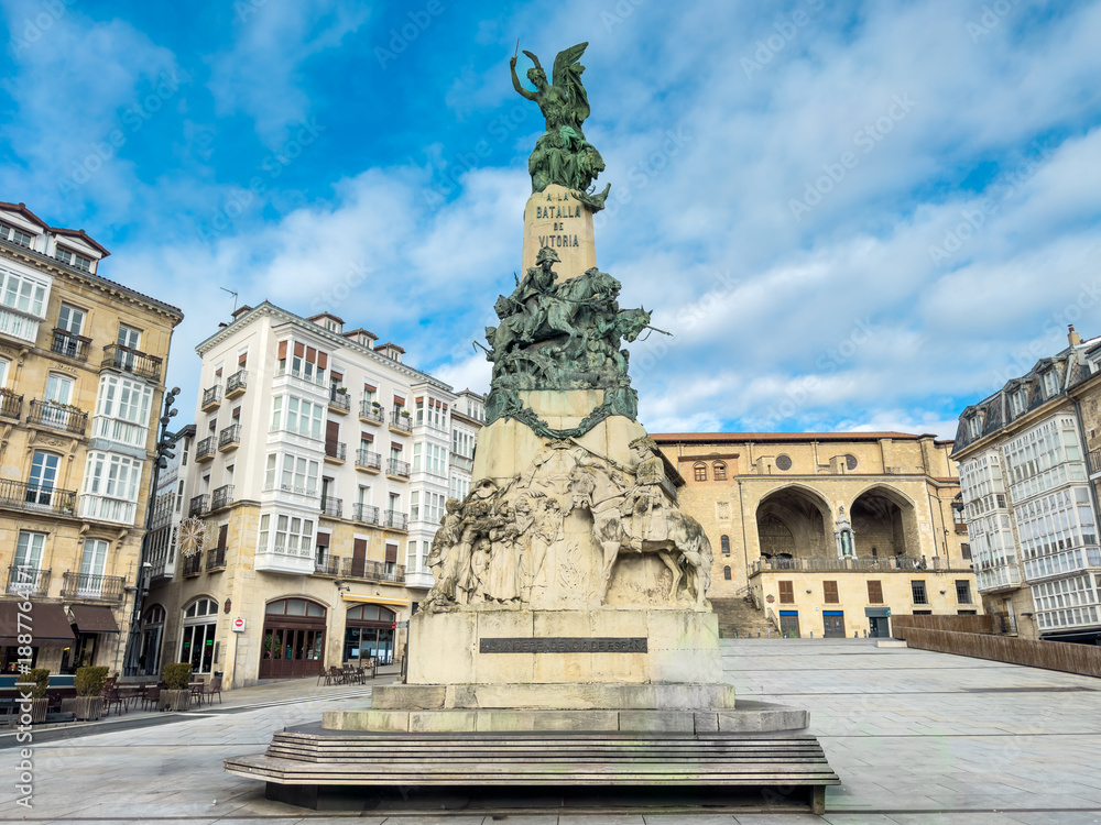 Fototapeta premium View of Plaza de la Virgen Blanca in Vitoria-Gasteiz, Spain, featuring the Battle of Vitoria Monument. Historic architecture surrounds the square, creating a classic Basque urban landmark scene. 