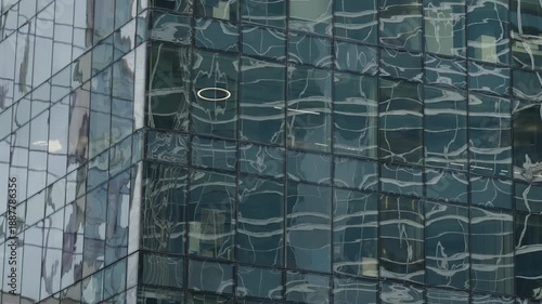 Wallpaper Mural Abstract reflections ripple across the glass facade of a modern office skyscraper, revealing distorted patterns and a grid of windows that emphasize contemporary architecture Torontodigital.ca