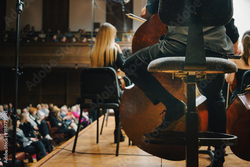 Double bass player of the symphony orchestra on the chair