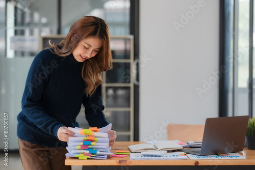Fotografía Asian businesswoman arranging documents on her desk.