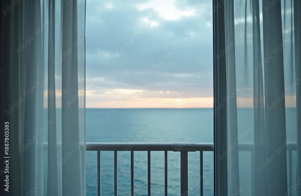 Naklejka premium View of ocean sunset through sheer curtains from hotel room balcony. Calm water and sky with soft clouds. Peaceful atmosphere for vacation or relaxation.