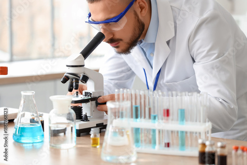 Male scientist looking thro...