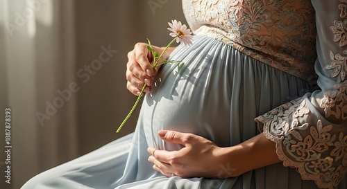 Pregnant woman holds a delicate flower against her belly.