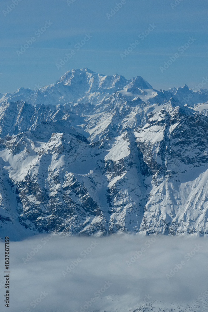Obraz premium Dramatic Rocky Mountain Peaks Rising Above Misty Cloud Layer in Swiss Alps
